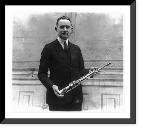 Historic Framed Print, Tomm Brown, who claims to have had the first saxaphone act, posed with 1st saxaphone made by Adolph Sax, the inventor, 17-7/8" x 21-7/8"